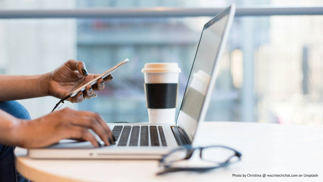 Hands looking at laptop and phone