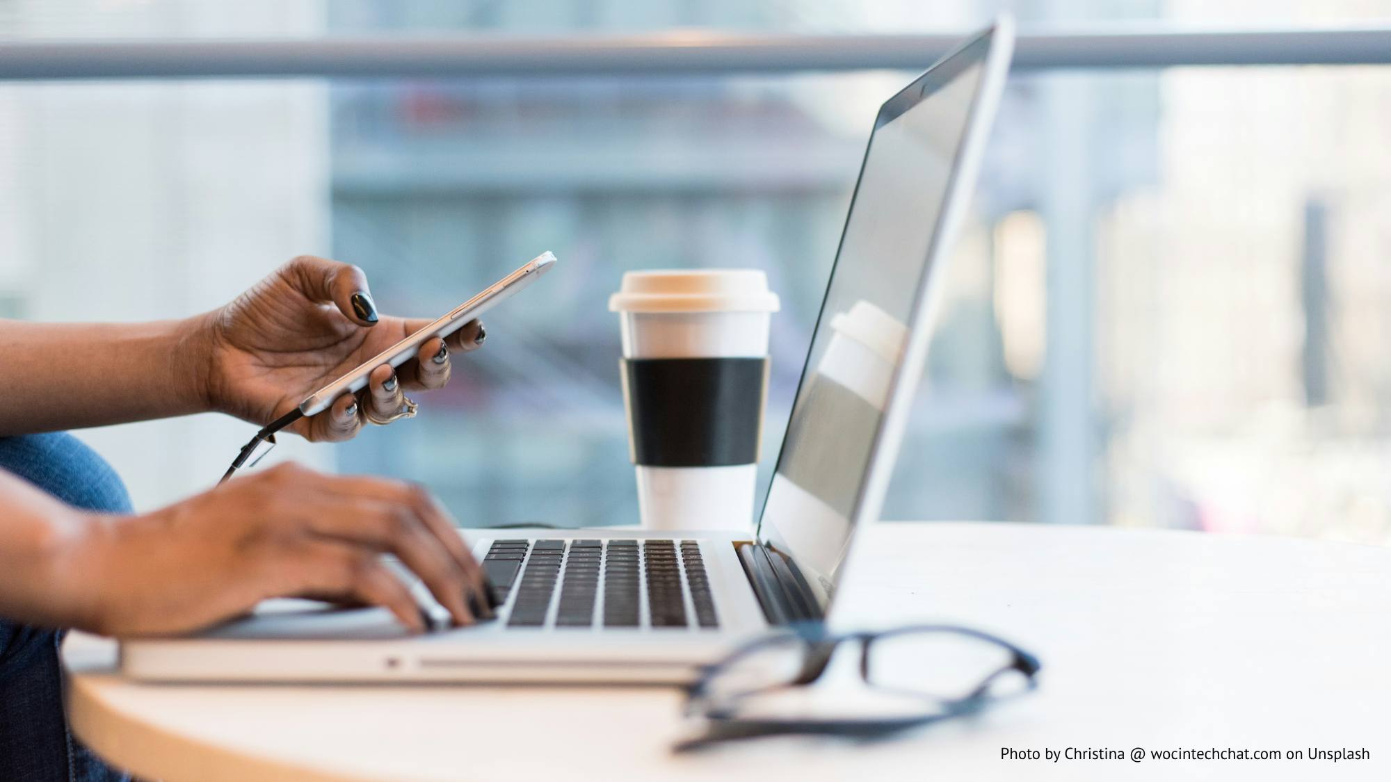 Hands looking at laptop and phone